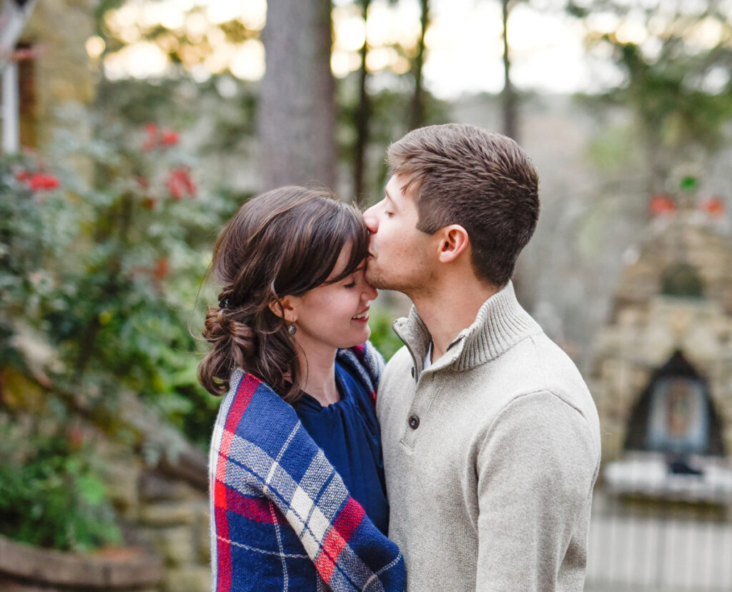 Man kissing woman on her forehead